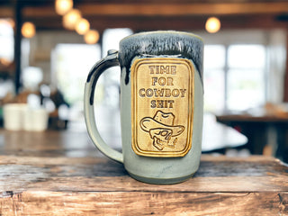 A gray and black mug with a design for cowboys